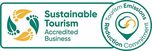 Logo of Sustainable Tourism Accredited Business with a circular leaf and foot design.