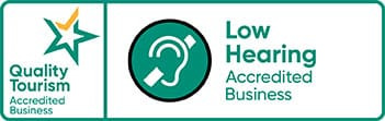 Logos for Quality Tourism and Low Hearing Accredited Business with ear icon.